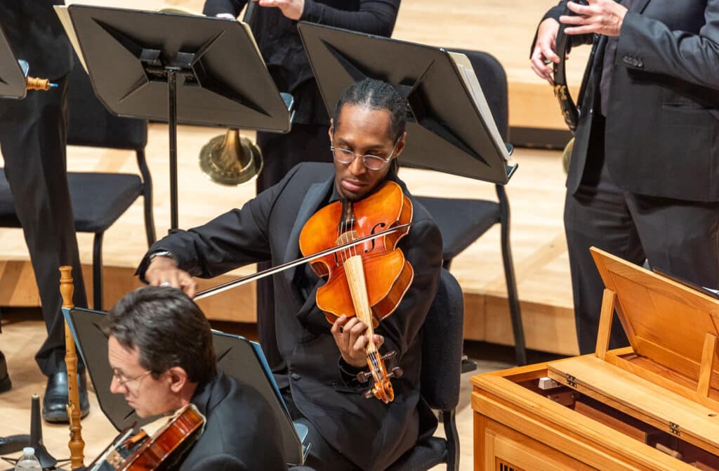 A black man playing the violin in the Washington Bach Consort orchestra