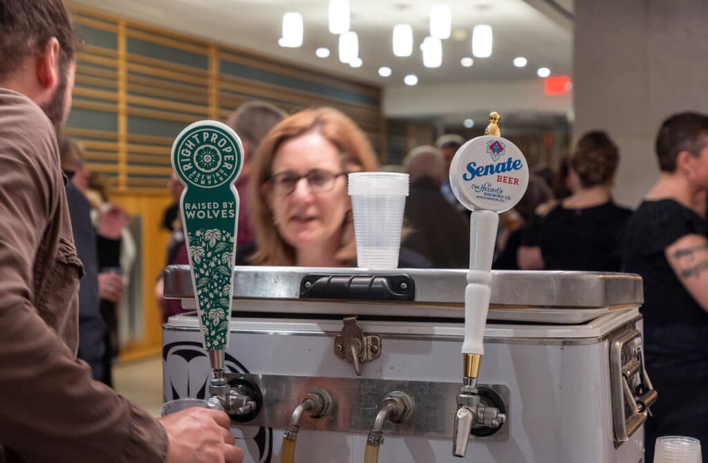 A volunteer serving beer to a patron