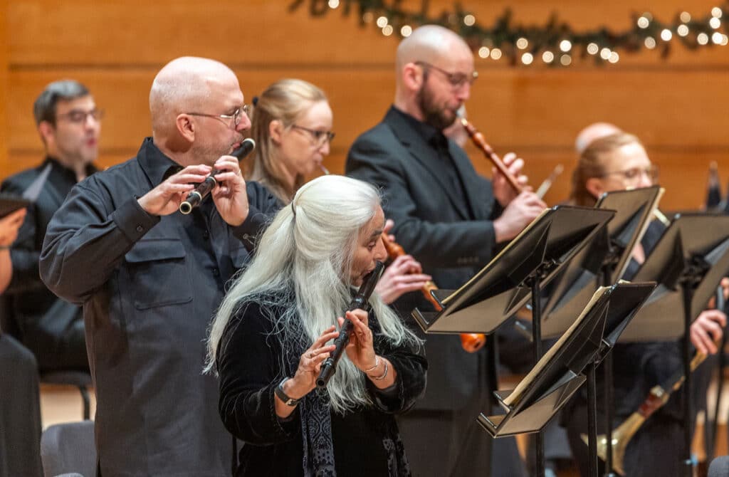 Orchestral close up of musicians playing flutes and oboes