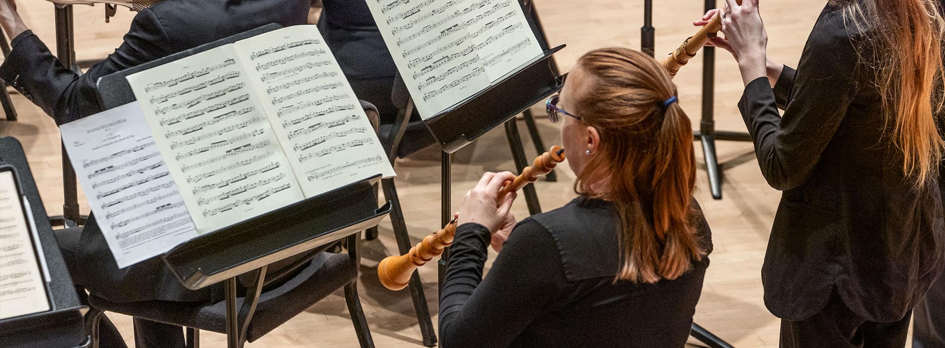 Two women playing oboes at a live performance