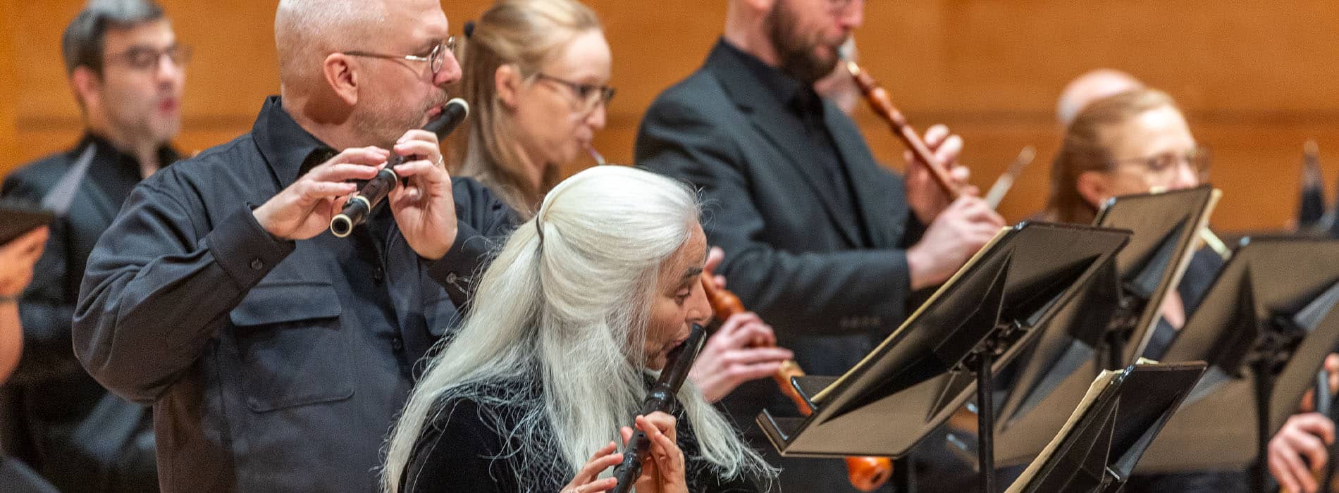 Orchestral close up of musicians playing flutes and oboes